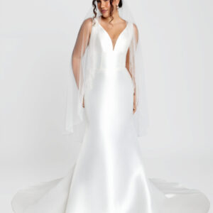 Bride to be wearing a classic wedding dress with a fit and flare style and a deep v cut neckline.