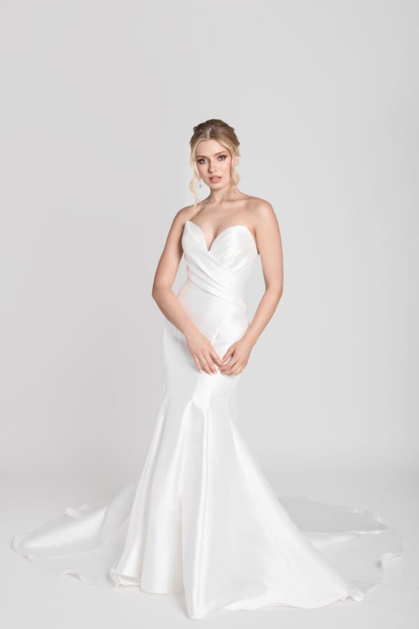 Bride to be wearing a simple fit and flare wedding dress with a deep sweetheart neckline and crossover folding on bodice.