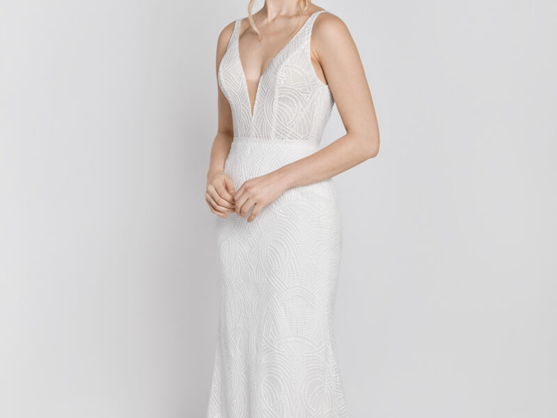 Stunning lace wedding dress with a deep v cut and a simple silhouette worn by a bride to be.