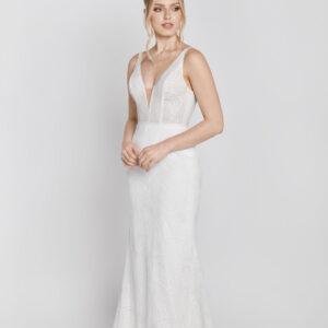 Stunning lace wedding dress with a deep v cut and a simple silhouette worn by a bride to be.