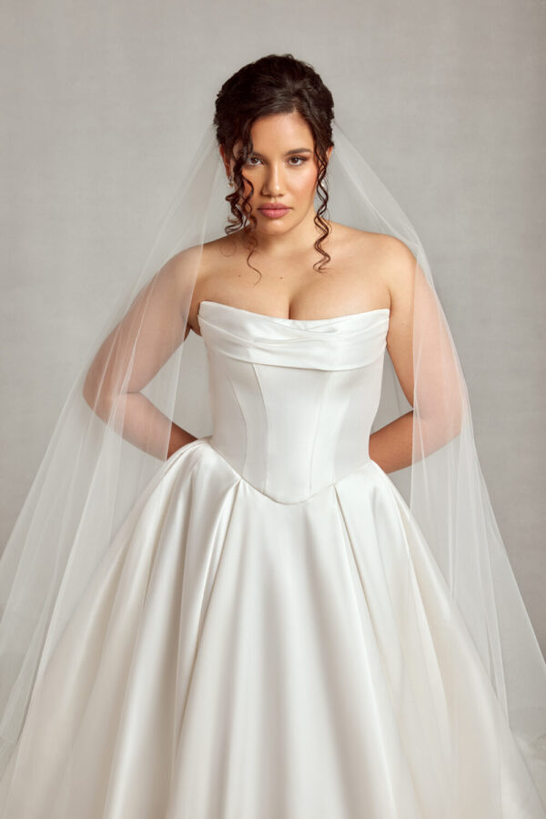 Traditional style bride wearing a corset wedding dress with a basque waistline and full skirt.