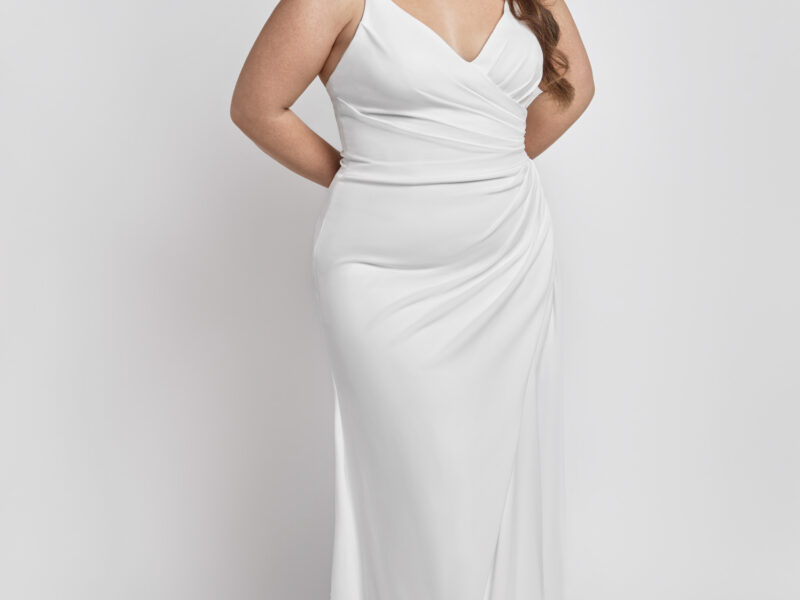 A classic style wedding dress with spaghetti straps and the fabric gathered at one hip.