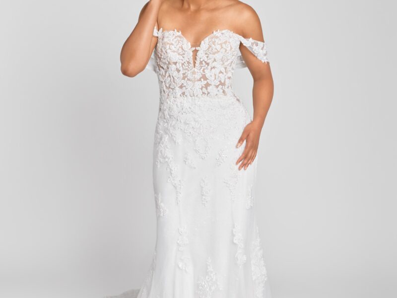 Lovely bride to be wearing a lace, fit and flare wedding dress with a sweetheart neckline, off the shoulder sleeves and a simple, flowing skirt.