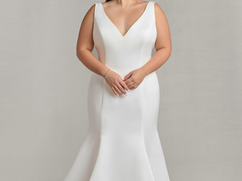 Stunning bride to be modeling a simple v cut wedding dress in a fit and flare shape.