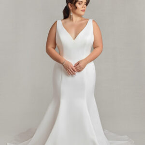 Stunning bride to be modeling a simple v cut wedding dress in a fit and flare shape.