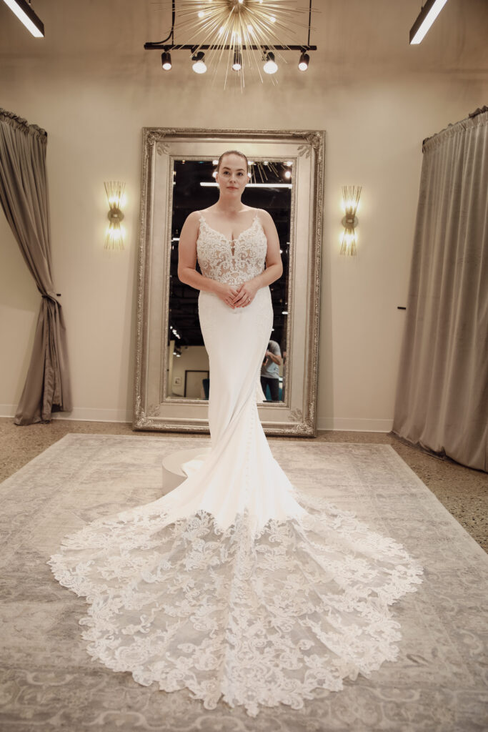 Elegant bride in a white mermaid wedding dress with an extensive lace train.