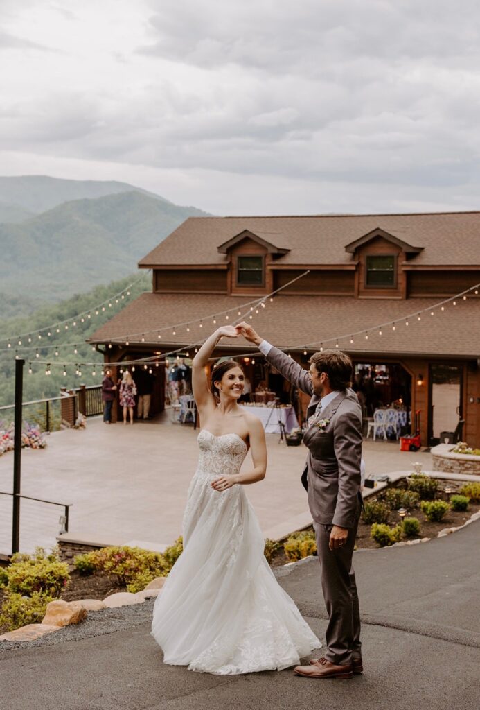 Bride and groom dancing under twinkling lights at a mountain lodge venue.