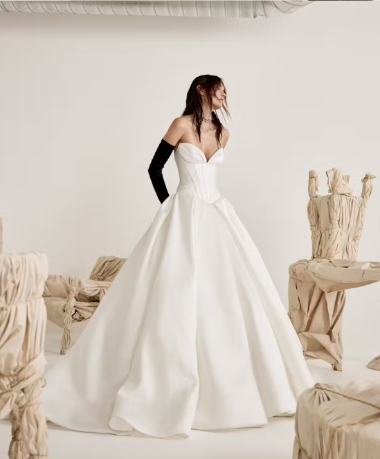 Fashion-forward bride in a striking basque gown with dramatic black gloves.