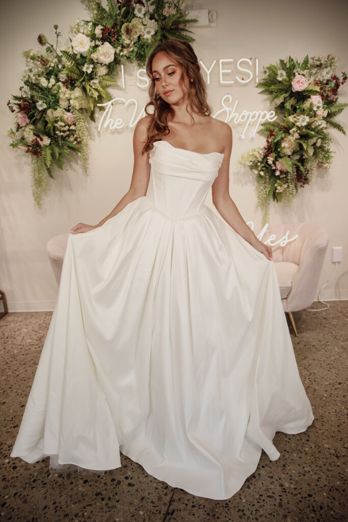 Elegant bride in a minimalist basque waist gown, posing gracefully.