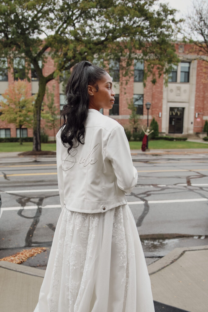 Bride in denim jacket, detailed with 'Bride' on the back, in urban setting.