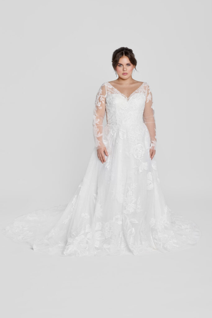 Plus-size bride in a long sleeve lace wedding dress, full-length portrait.