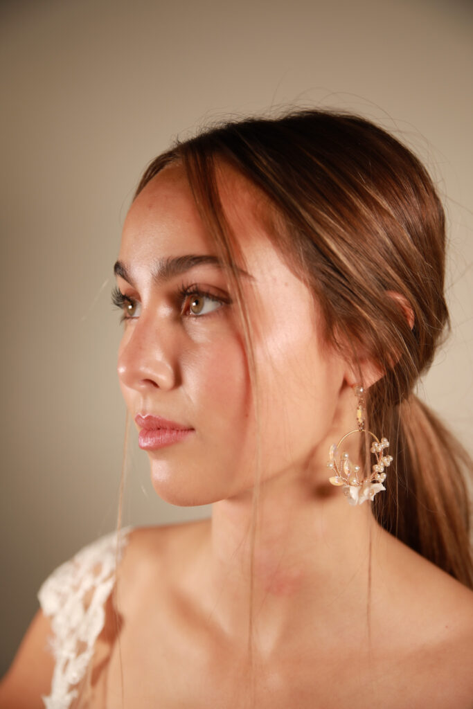 Side profile of a bride wearing unique floral hoop earrings, highlighting a minimalist and elegant bridal jewelry style.