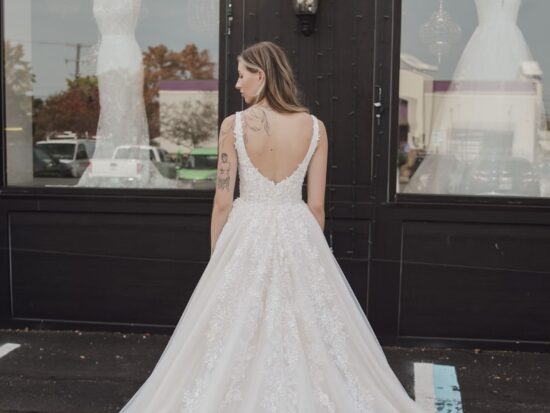 A back view of a floral lace ballgown wedding dress with a dramatic train, delicate detailing, and a classic open-back design.