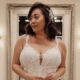 Close-up of a bride in a lace wedding gown featuring intricate floral patterns and a deep neckline, paired with a soft, glamorous hairstyle.