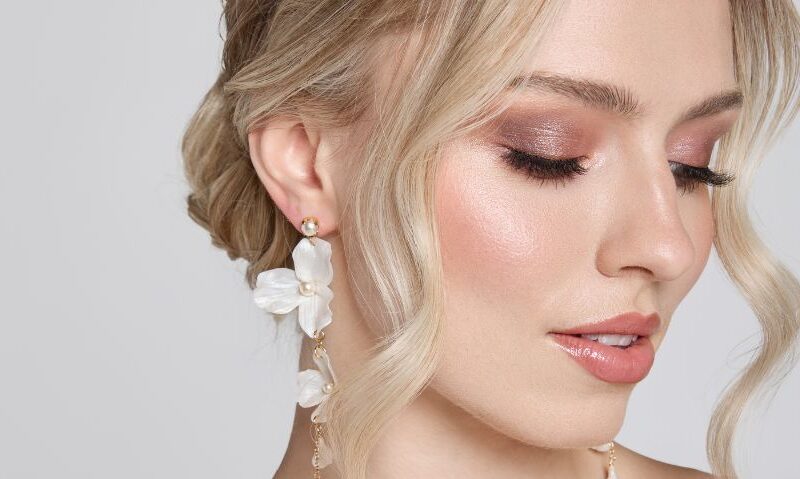 Side profile highlighting intricate white flower drop earrings, perfect for a wedding day accessory.