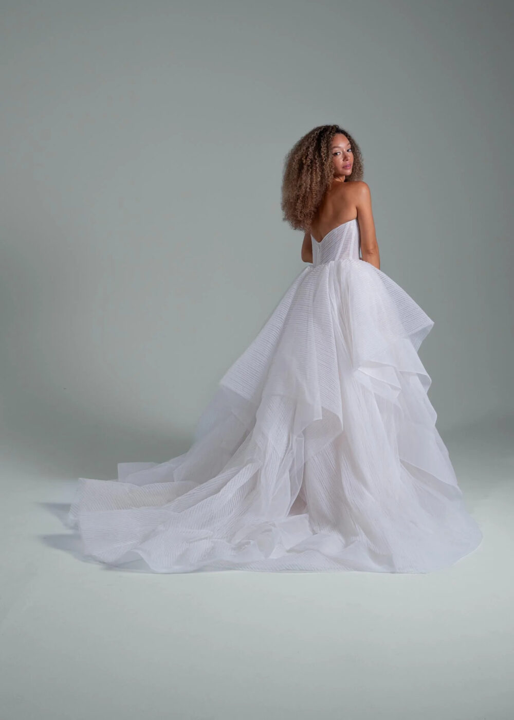 A woman wearing a Hailey Paige wedding dress made of textured fabric.
