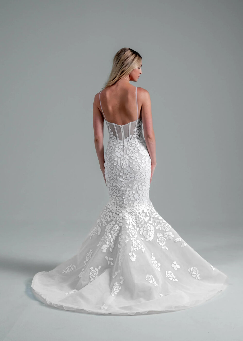 A woman wearing a lace mermaid wedding dress with a ribbed bodice.