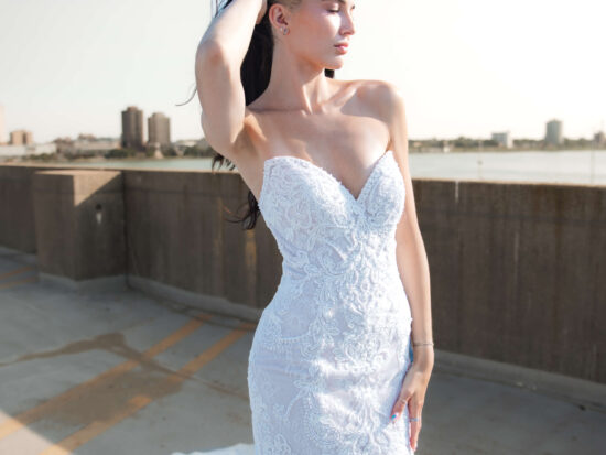 woman in bridal dress sunbathing in city setting