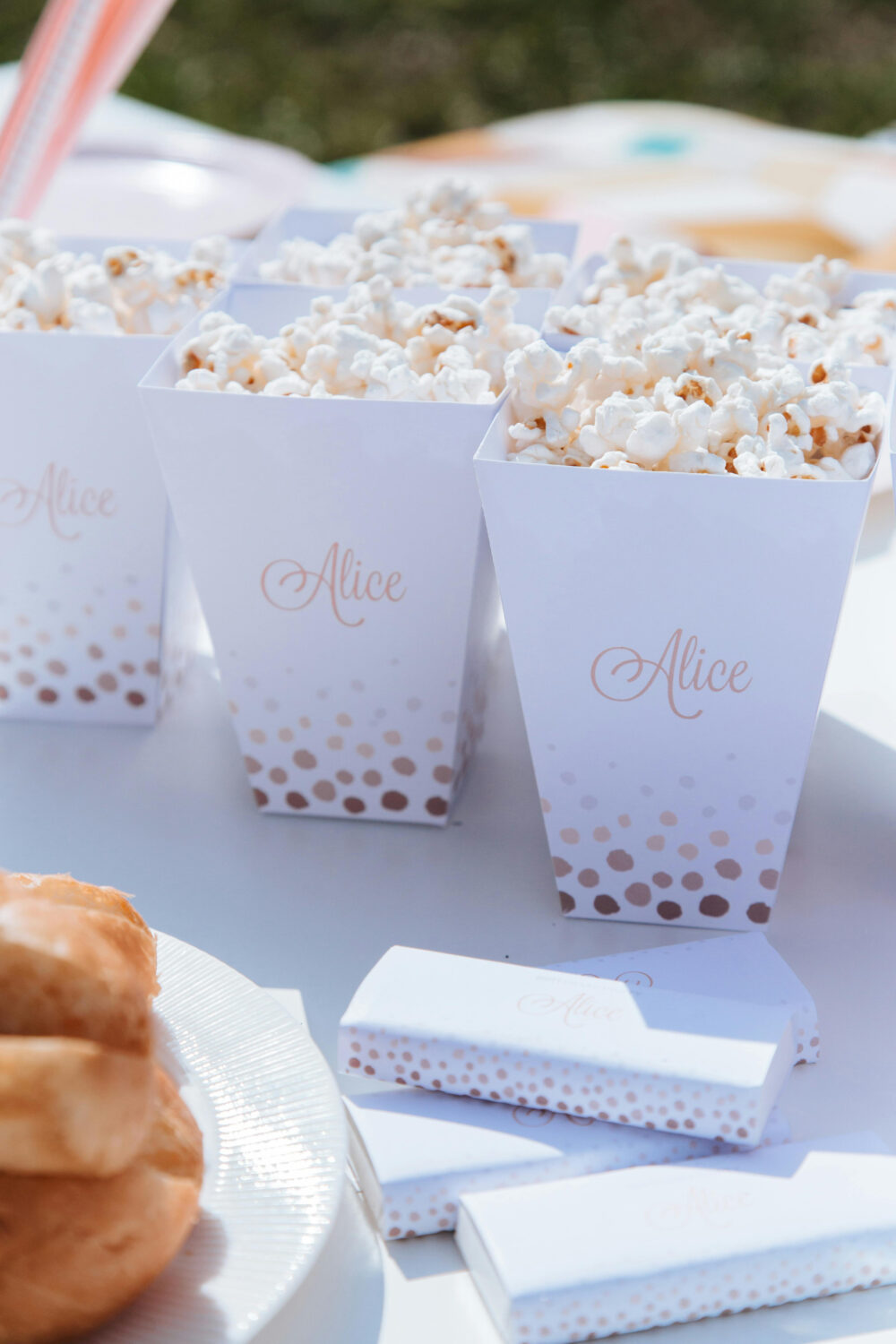 Wedding snacks table with popcorn boxes and personalized details.