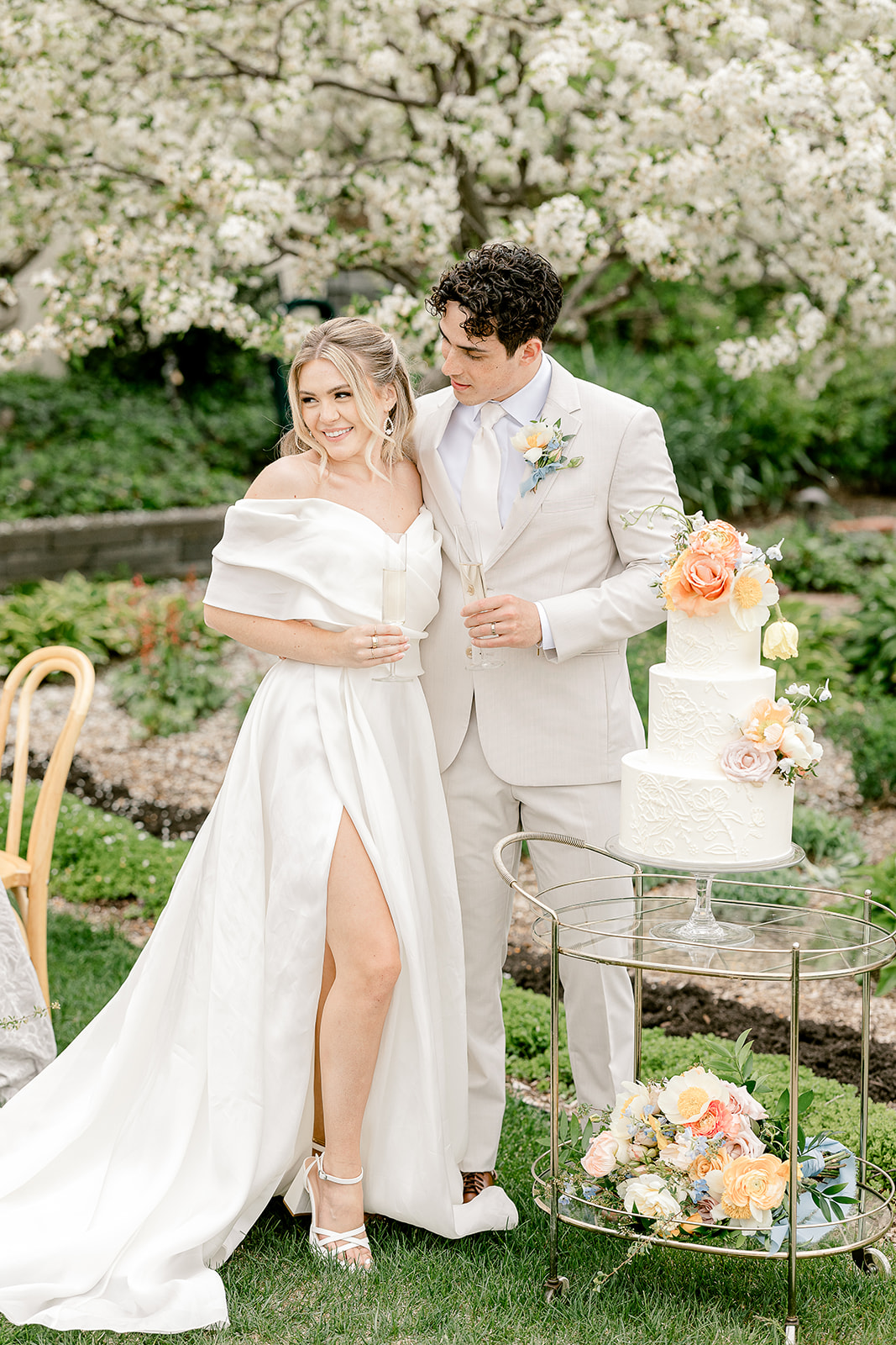 Bride and groom standing under blooming tree during spring wedding.