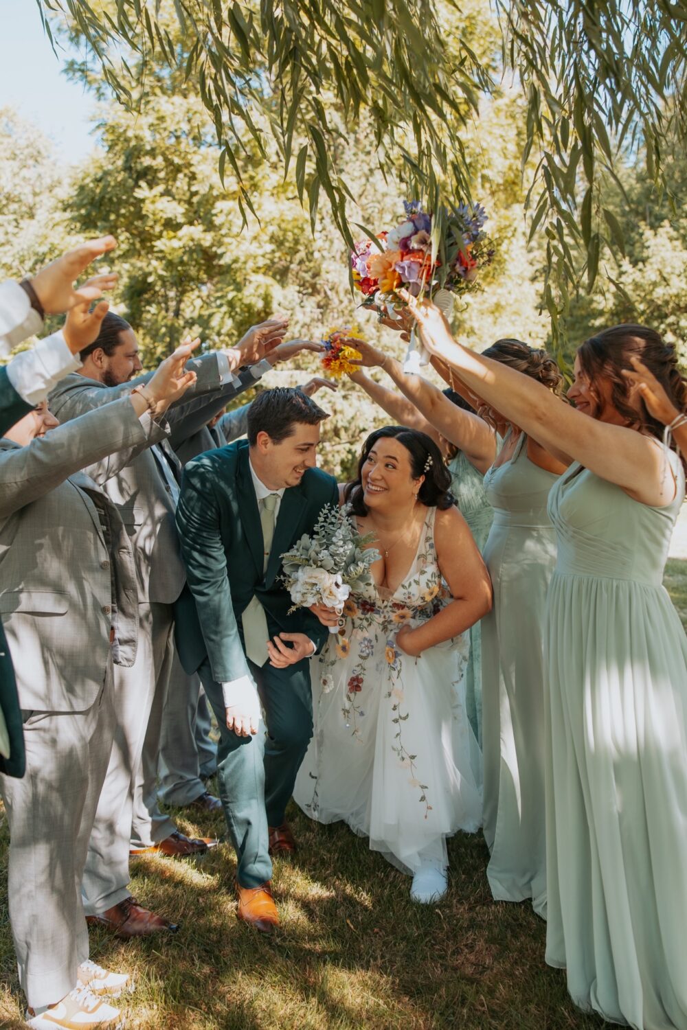 Bride and groom walking joyfully through guests throwing petals outdoors.