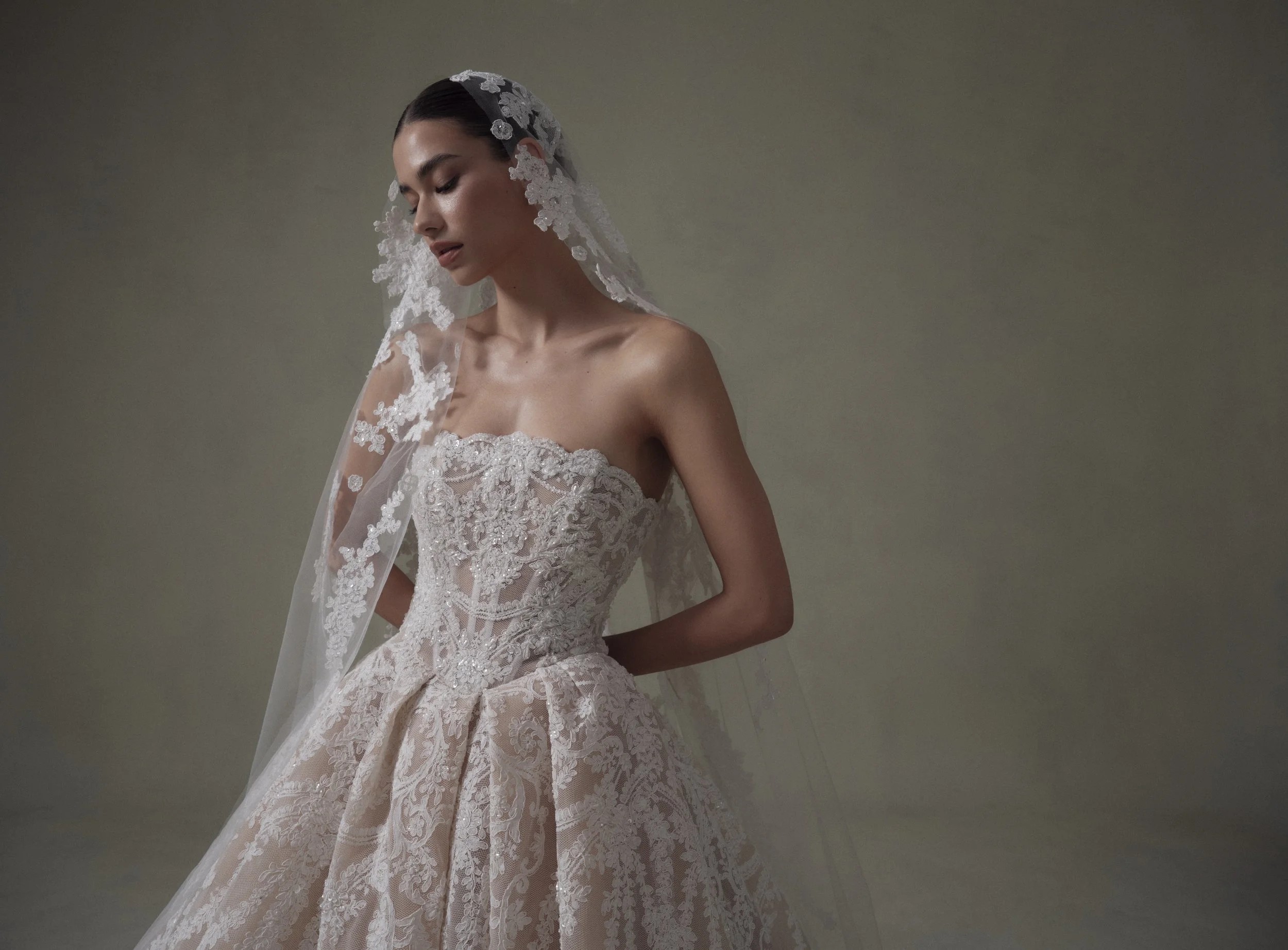 Stunning bride wearing a sleeveless lace wedding dress with a matching cathedral bridal veil.