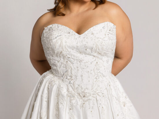 Close-up of a smiling bride wearing a strapless lace wedding gown with a sweetheart neckline and full skirt.