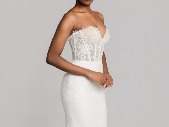 Bride wearing a strapless fitted lace wedding gown with a structured bodice, posing against a neutral background.