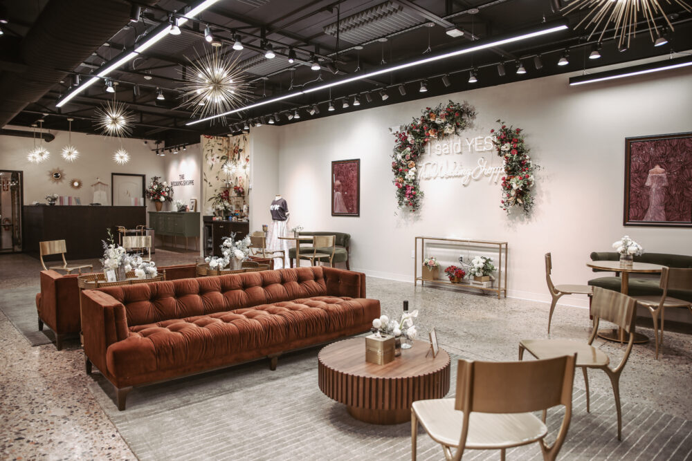 Open bridal boutique showroom with lounge seating, floral décor, reception area, and illuminated "I Said Yes" display.