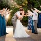 Bride and groom kiss during a sparkler exit as wedding guests line both sides of the walkway holding sparklers.