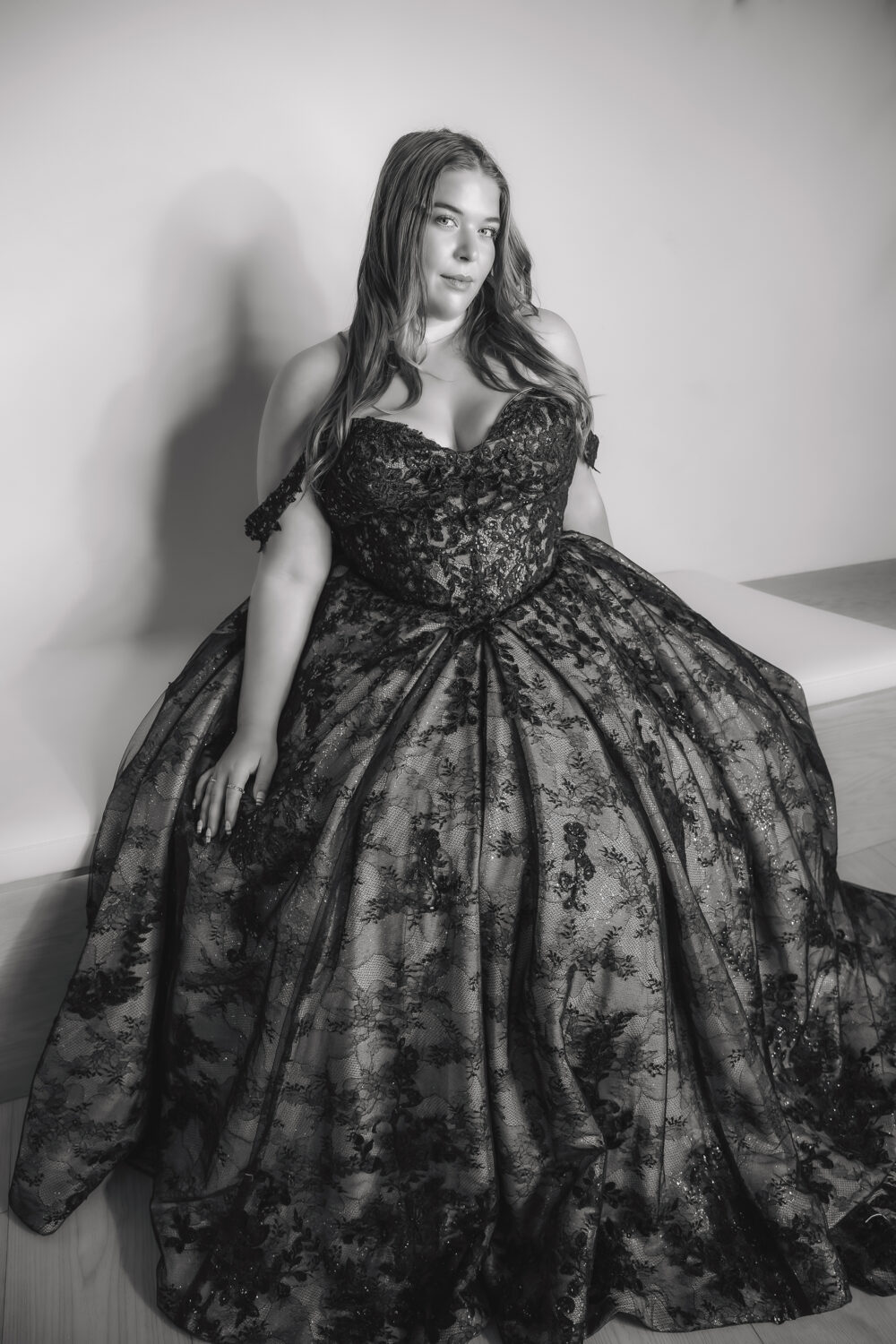Bride wearing a black wedding dress with a dramatic lace overlay in an elegant interior.