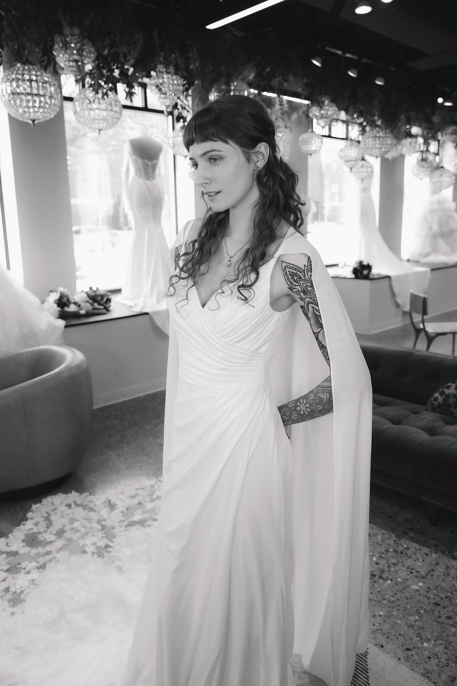 Bride in a white wedding dress posing in an elegant bridal shop.