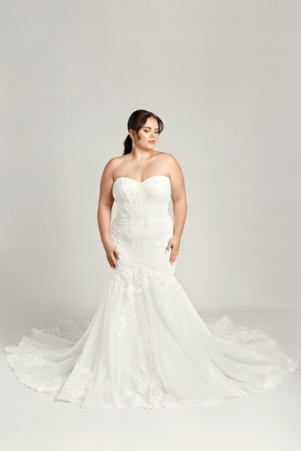 A plus size bride wearing a sweetheart neckline, fit and flare wedding dress.