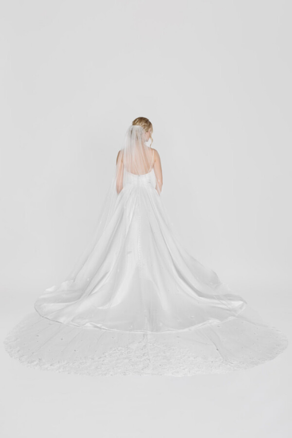 Classic bridal ball gown with a soft, scoop back and a full skirt with hidden pockets. The bride is also wearing a cathedral length veil.