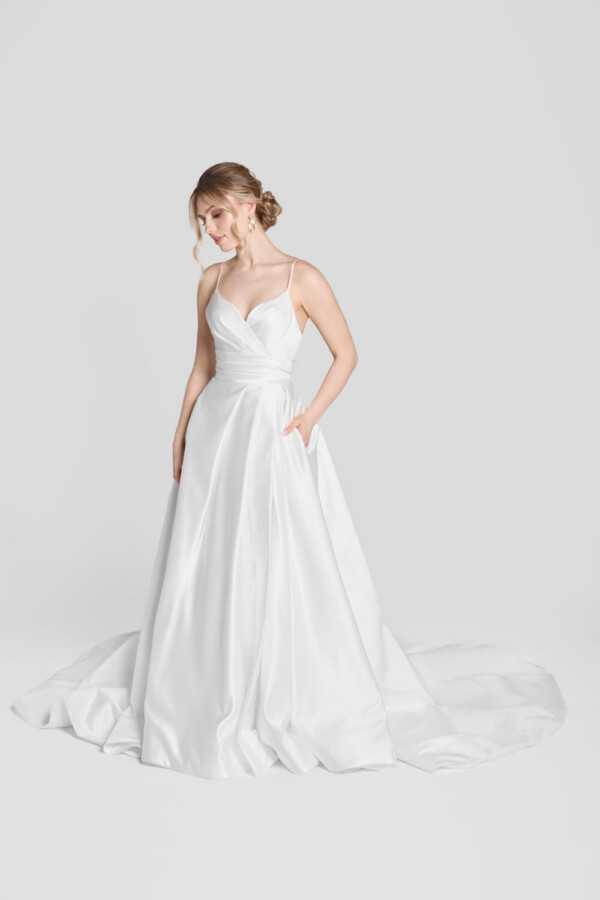 Classic bridal ball gown with a soft, sweetheart neckline and layered folding on the bodice. The skirt is full and has hidden pockets.