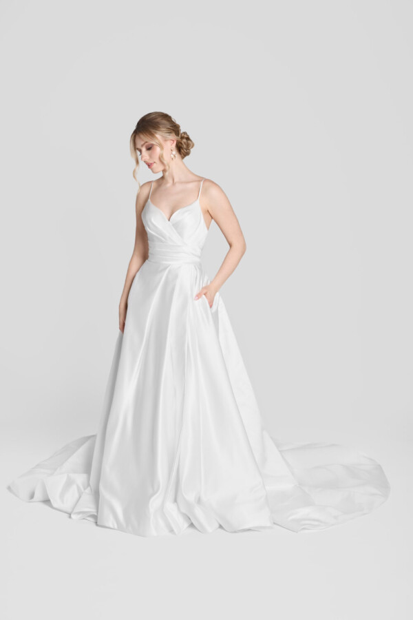 Classic bridal ball gown with a soft, sweetheart neckline and layered folding on the bodice. The skirt is full and has hidden pockets.