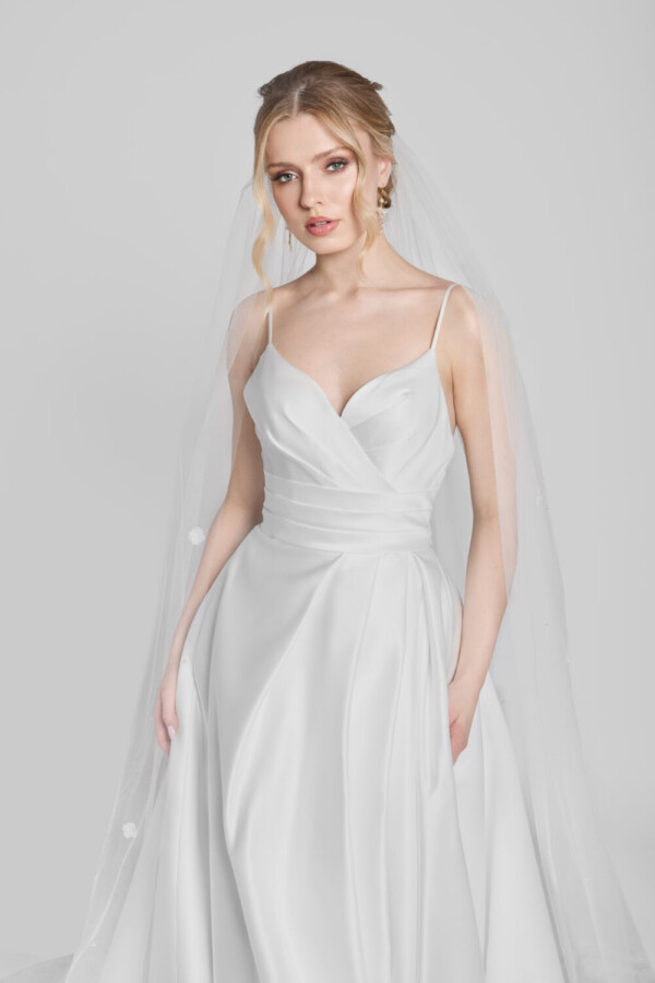 Classic bridal ball gown with a soft, sweetheart neckline and layered folding on the bodice. The skirt is full and has hidden pockets.