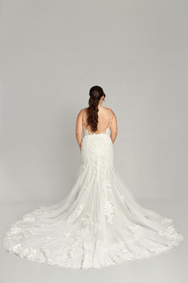 Gorgeous plus size bride wearing a bohemian wedding dress with spaghetti straps and floral detailing throughout.