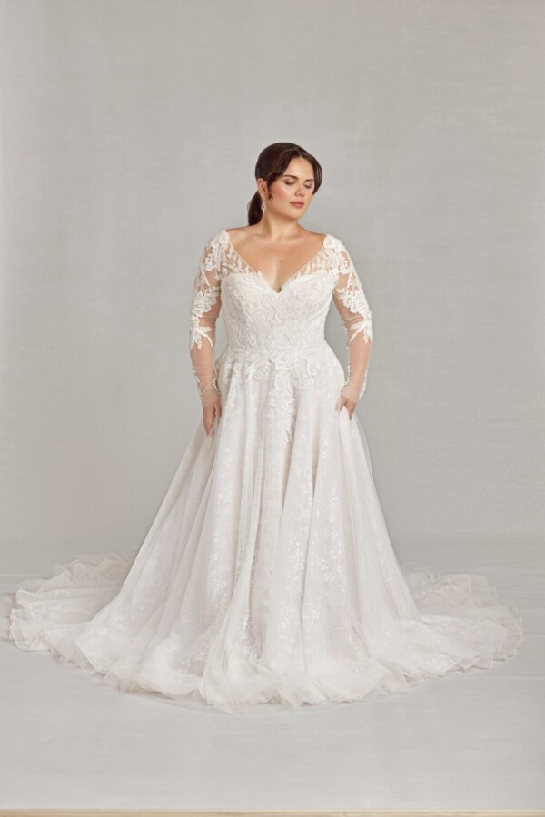 Beautiful plus size bride wearing a bohemian wedding dress with lace long sleeves.