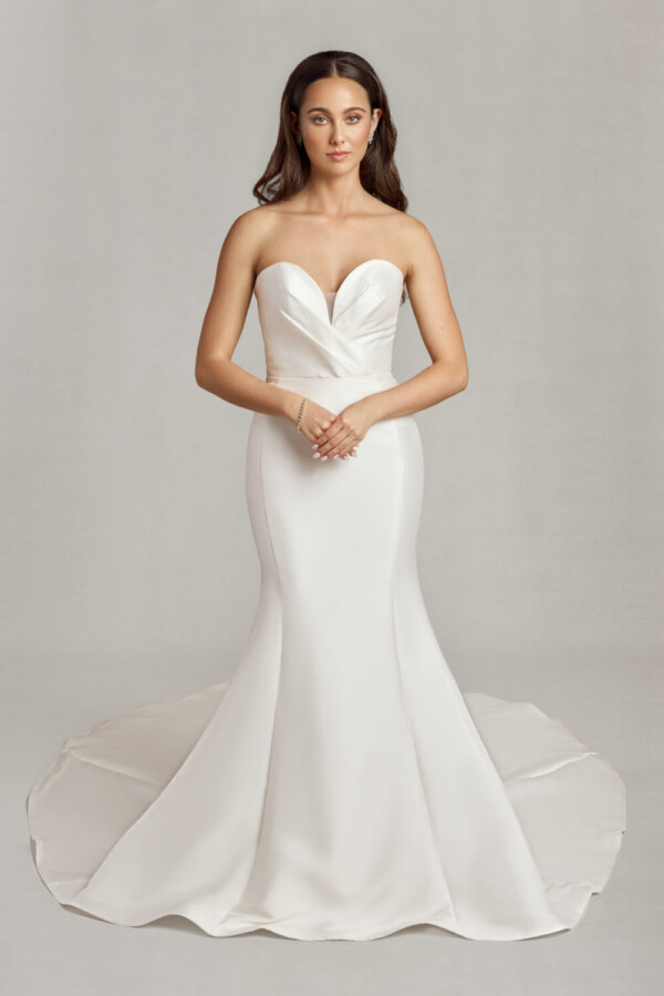 Bride wearing her classic, form fitting wedding dress with deep sweetheart neckline and crossover folding on the bodice.
