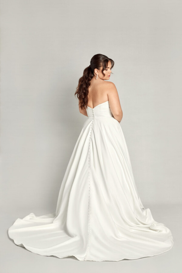Timeless bride to be wearing a simple wedding dress with a sweetheart neckline and buttons down the back.