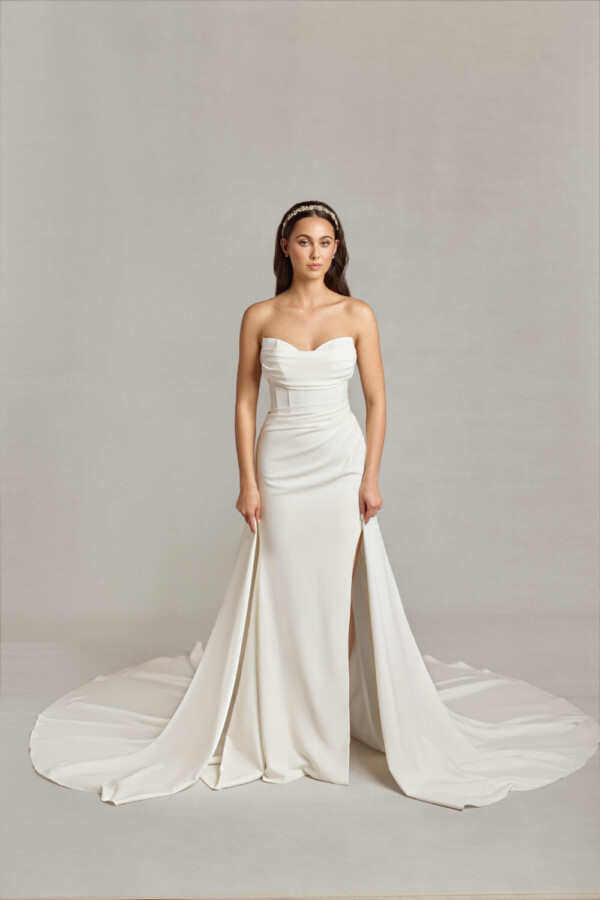 Bride wearing her form fitting wedding dress with sweetheart neckline and ruched folding on the bodice and a slit up the thigh.