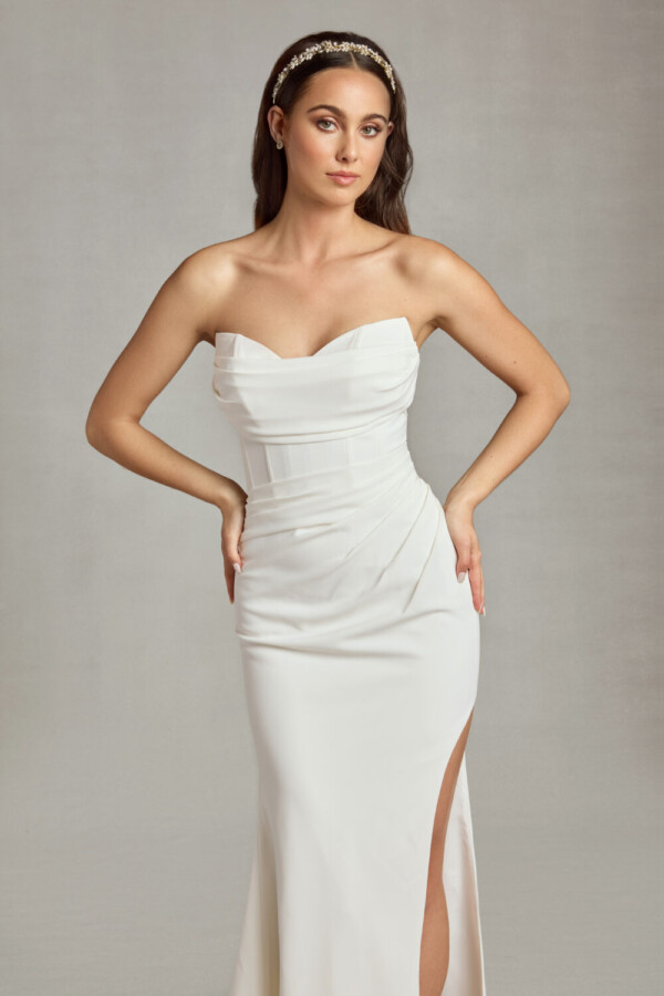 Bride wearing her form fitting wedding dress with sweetheart neckline and ruched folding on the bodice and a slit up the thigh.