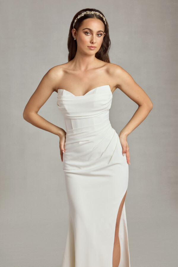 Bride wearing her form fitting wedding dress with sweetheart neckline and ruched folding on the bodice and a slit up the thigh.