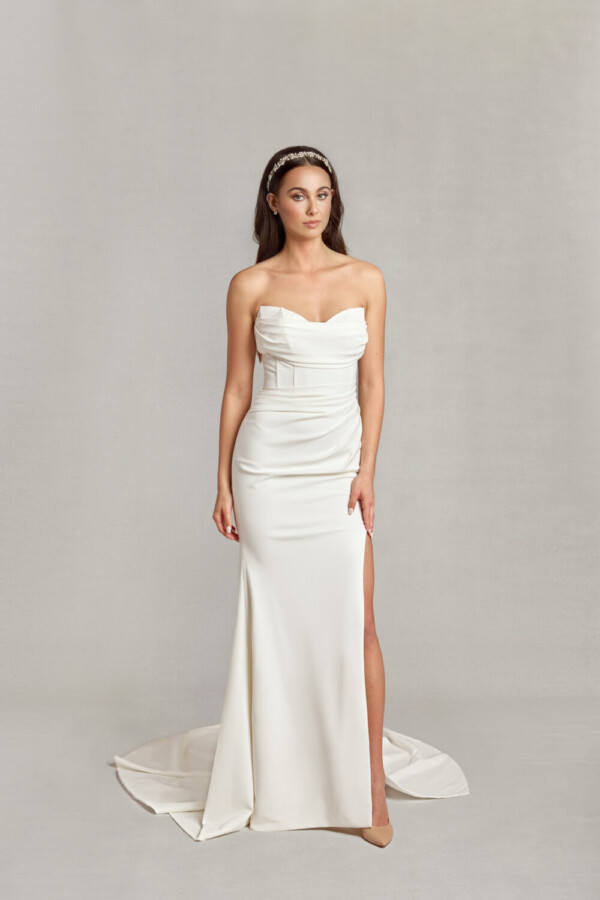 Bride wearing her form fitting wedding dress with sweetheart neckline and ruched folding on the bodice and a slit up the thigh.