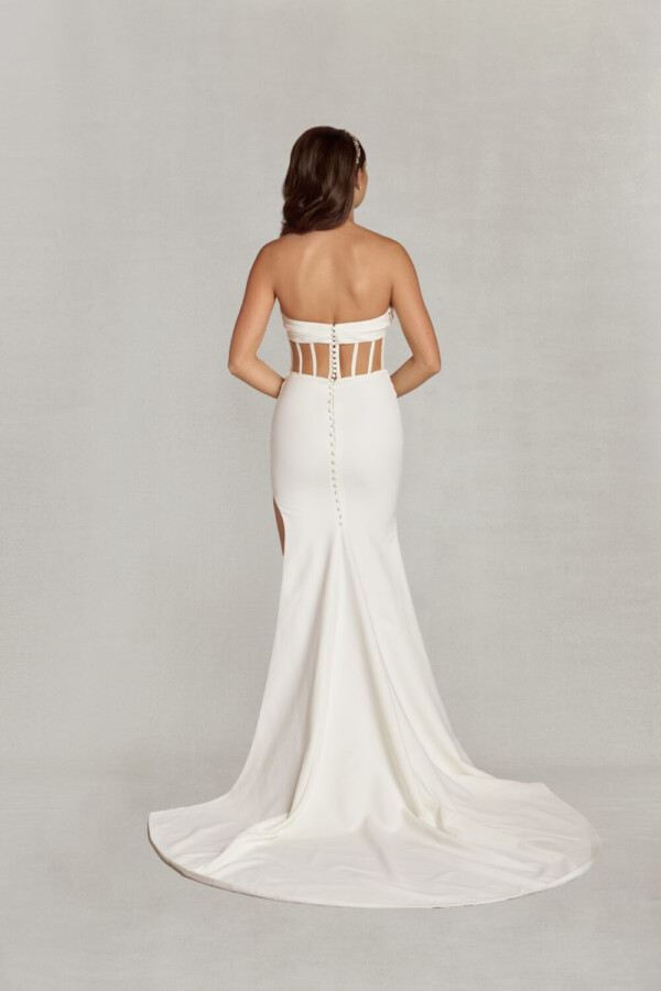 Bride wearing her form fitting wedding dress with back keyhole cut outs and buttons down the spine.