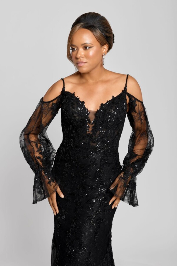 Gothic wedding dress being worn by a confident bride to be. The black wedding dress has long lace sleeves and black, beading on the bodice.