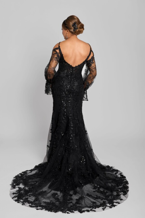 Gothic wedding dress being worn by a confident bride to be. The black wedding dress has long lace sleeves and black, beading on the bodice.