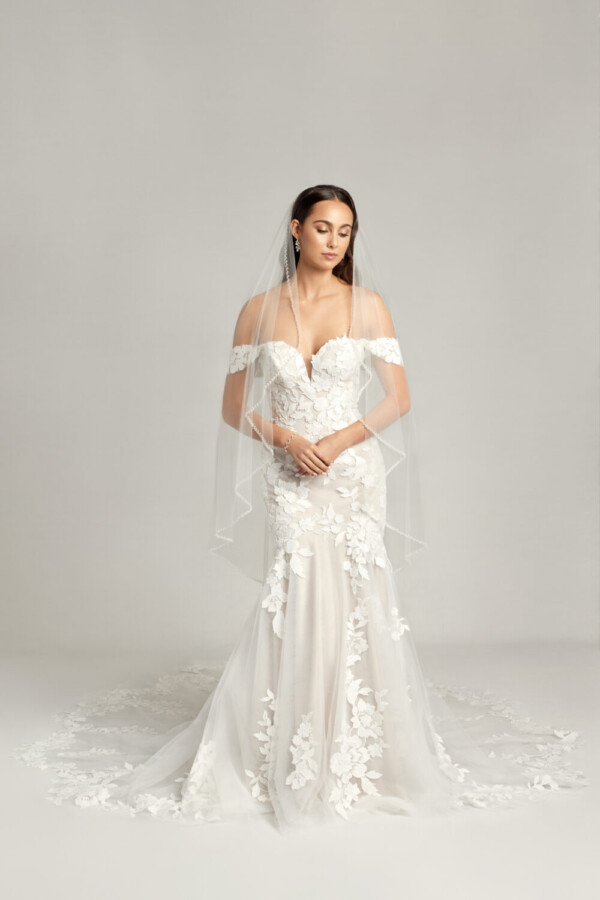 Ethereal wedding dress with off the shoulder sleeves and a sweetheart neckline, the lace floral appliques move throughout the dress and train.