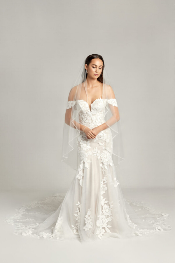 Ethereal wedding dress with off the shoulder sleeves and a sweetheart neckline, the lace floral appliques move throughout the dress and train.